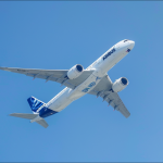 Ein Airbus-Flugzeug ist mitten im Flug vor einem klaren blauen Himmel.