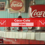 eine Theke in einem Retro-Diner mit Coca-Cola-Schildern und einer Coca-Cola-Flasche darauf, , darüber ein Coca-Cola NEWS Banner