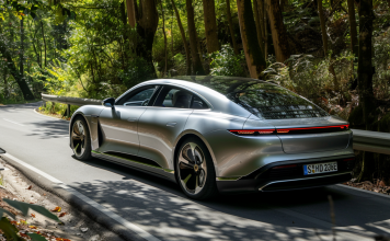 ein silbernes Elektroauto, die auf einer von Grün umgebenen Straße fährt