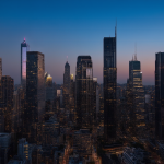 Stadtbild bei Abenddämmerung mit beleuchteten und dunklen Wolkenkratzern