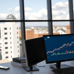 Büro mit Stadtansicht und Computer mit Aktienmarkt-Dashboard