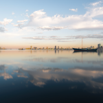 Stadtansicht mit Spiegelung im Wasser und überlagerten Börsentickern