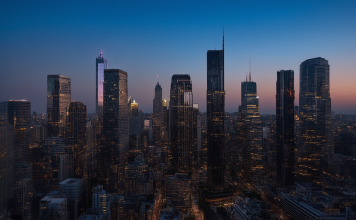 Stadtbild bei Abenddämmerung mit beleuchteten und dunklen Wolkenkratzern