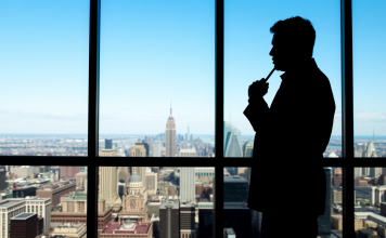 Silhouette eines nachdenklichen Traders vor Panoramafenster