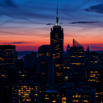 Finanzviertel-Skyline bei Dämmerung mit beleuchteten Fenstern.