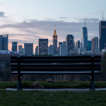 Parkbank mit Blick auf das Finanzviertel bei Dämmerung