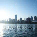 Finanzbezirk am Wasser bei Sonnenaufgang mit Börsendaten