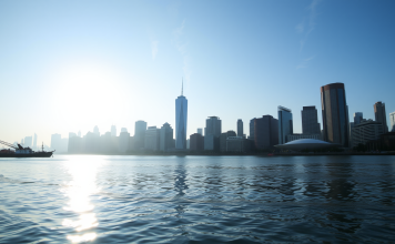 Finanzbezirk am Wasser bei Sonnenaufgang mit Börsendaten