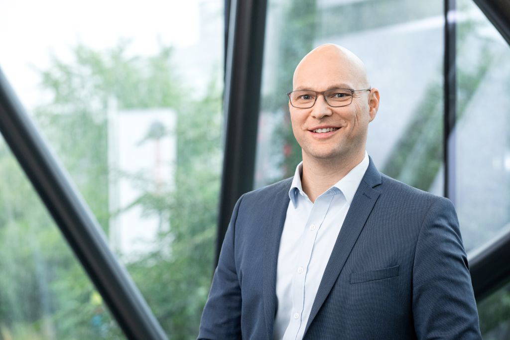 Portrait von Steyr-CEO Julian Cassutti aus dem Jahre 2024 (dunkles, Sakko, weißes Hemd ohne Krawatte)